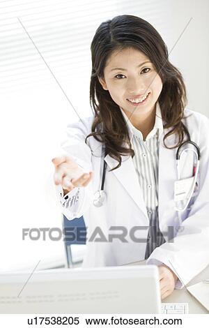Stock Photography - Female doctor holding out her hand. Fotosearch