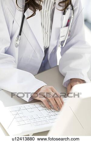 Stock Image - Female doctor using a computer. Fotosearch