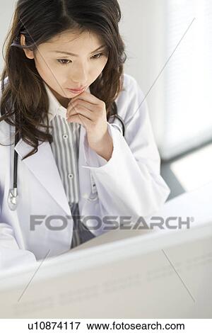 Stock Photo - Female doctor using a computer. Fotosearch