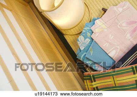 Stock Image - Folded yukata next to a lantern in a Japanese room. Fotosearch