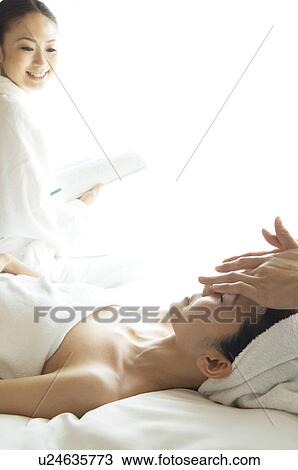 Stock Image - Friends take turns receiving massages. Fotosearch