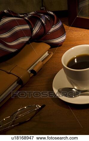 Stock Photo - Glasses, tie, diary and coffee on table. Fotosearch