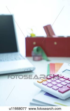 Laptop on desk with files and calculator View Large Photo Image Stock Photo - Laptop on desk with files and calculator. Fotosearch