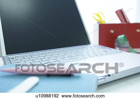 Laptop on desk with notebook and pen View Large Photo Image Stock Image - Laptop on desk with notebook and pen. Fotosearch