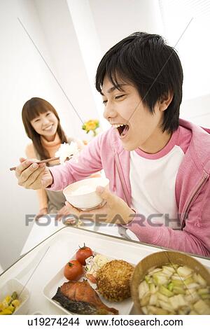 Picture - Man having a meal in his hospital bed. Fotosearch