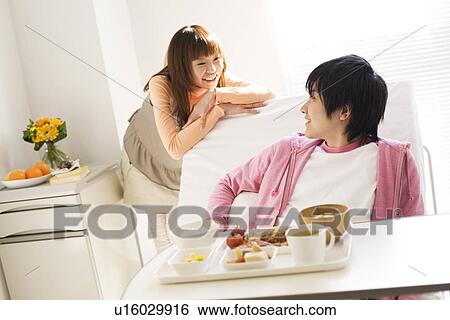Stock Photograph - Man having a meal in his hospital bed. Fotosearch