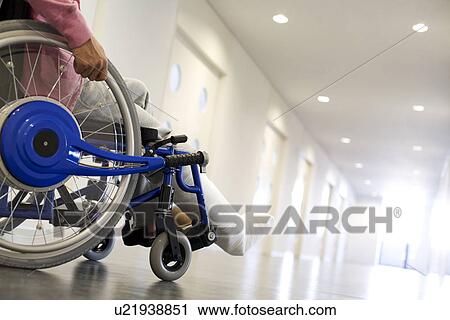 Stock Image - Man with broken leg in a wheelchair. Fotosearch