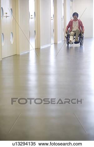 Stock Photography - Man with broken leg in a wheelchair. Fotosearch