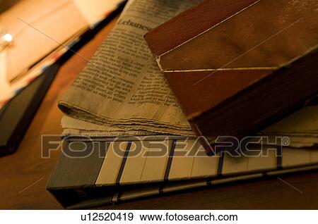 Stock Photo - Newspaper and old book on desk. Fotosearch