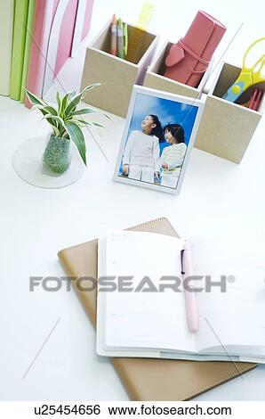 Stock Photograph - Notebooks on desk with pen. Fotosearch