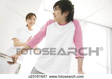 Nurse assisting a patient with rehabilitation View Large Photo Image Stock Photo - Nurse assisting a patient with rehabilitation. Fotosearch