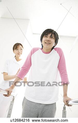 Nurse assisting a patient with rehabilitation View Large Photo Image Stock Photograph - Nurse assisting a patient with rehabilitation. Fotosearch