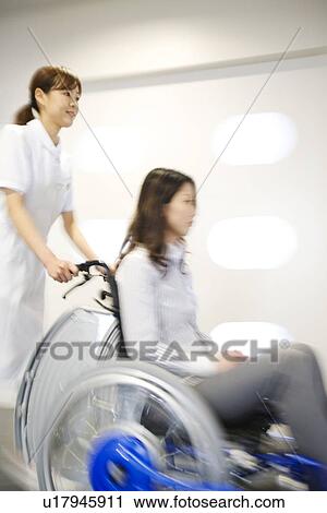 Nurse pushing patient in wheelchair along a corridor View Large Photo Image Stock Image - Nurse pushing patient in wheelchair along a corridor. Fotosearch