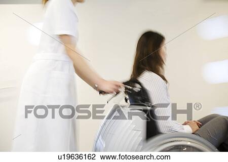Nurse pushing patient in wheelchair along a corridor View Large Photo Image Stock Image - Nurse pushing patient in wheelchair along a corridor. Fotosearch