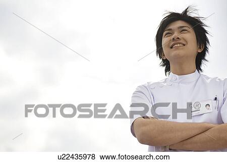 Nurse standing outside with folded arms View Large Photo Image Stock Photo - Nurse standing outside with folded arms. Fotosearch