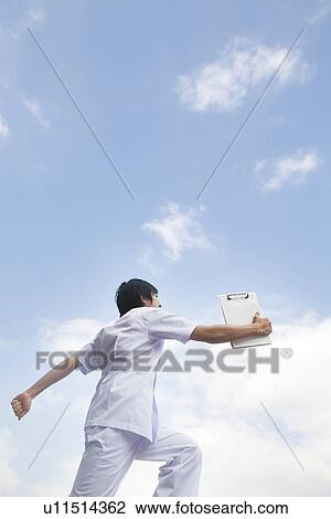 Stock Image - Nurse walking and holding chart. Fotosearch