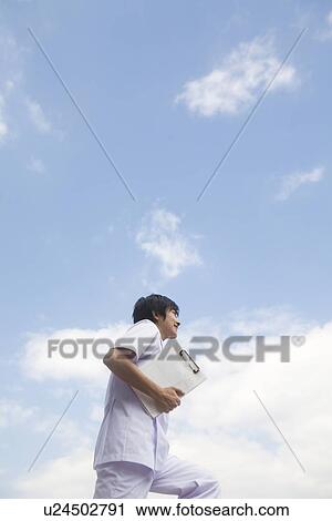 Nurse walking and holding chart View Large Photo Image Stock Image - Nurse walking and holding chart. Fotosearch