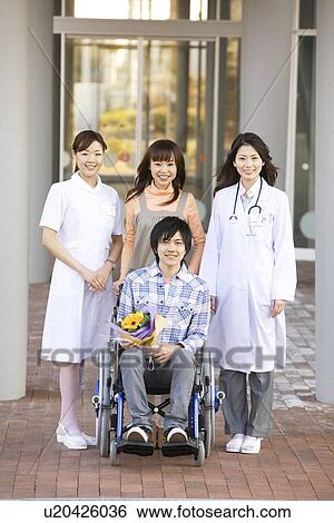 Stock Photograph - Patient with his doctor and nurse outside a hospital. Fotosearch