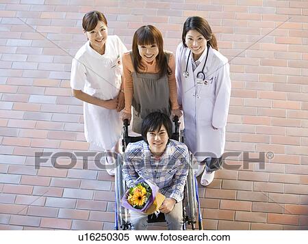 Stock Photography - Patient with his doctor and nurse outside a hospital. Fotosearch