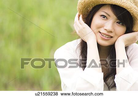 Stock Photo - Portrait of woman wearing straw hat. Fotosearch