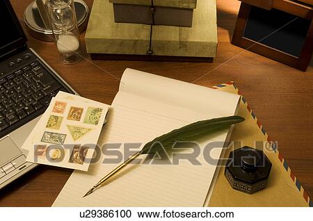 Stock Image - Quill pen on blank note pad. Fotosearch
