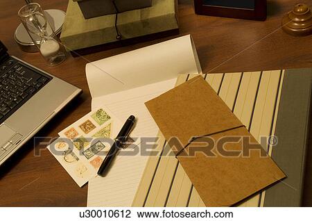 Stock Image - Quill pen on blank note pad. Fotosearch