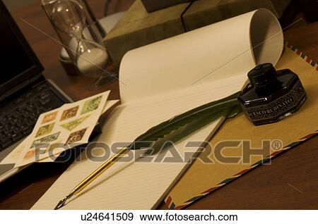 Stock Photo - Quill pen on blank note pad. Fotosearch