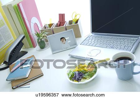 Stock Photo - Salad, coffee cup and laptop on desk. Fotosearch