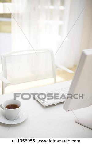Stock Photography - Table with personal computer and cup of tea. Fotosearch