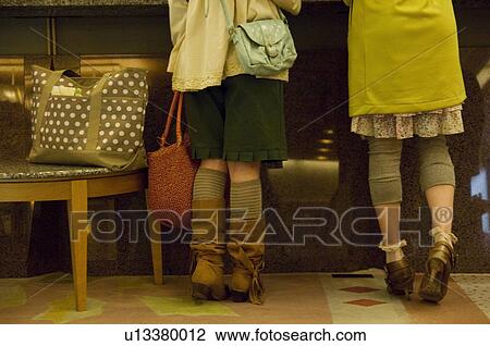 Two women checking into a hotel View Large Photo Image Stock Image - Two women checking into a hotel. Fotosearch