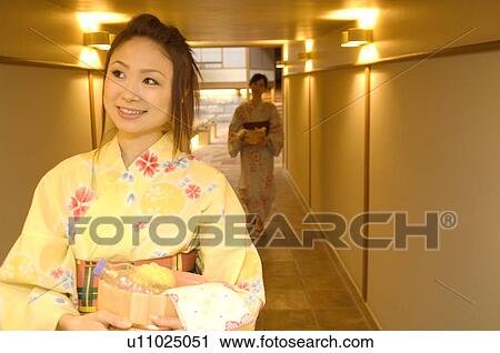 Two women wearing yukata walking through the corridor of a health spa View Large Photo Image Stock Image - Two women wearing yukata walking through the corridor of a health spa. Fotosearch