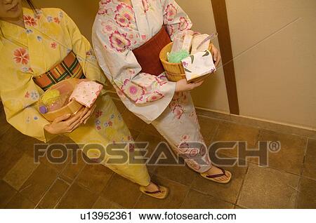 Two women wearing yukata walking through the corridor of a health spa View Large Photo Image Stock Image - Two women wearing yukata walking through the corridor of a health spa. Fotosearch