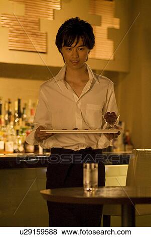 Stock Photo - Waiter carrying a plate of food to a table. Fotosearch