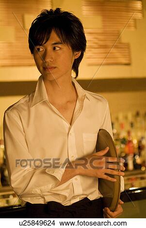 Picture - Waiter holding a tray at his side. Fotosearch