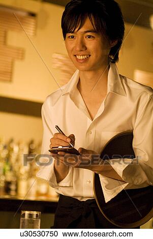 Stock Image - Waiter taking a customer's order. Fotosearch