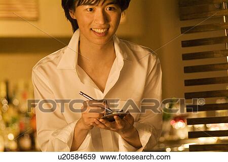 Waiter taking a customer's order View Large Photo Image Stock Photo - Waiter taking a customer's order. Fotosearch