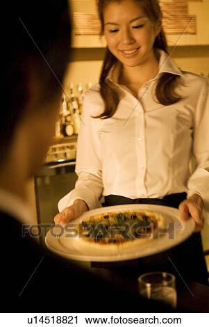 Waitress bringing a pizza to a table View Large Photo Image Stock Image - Waitress bringing a pizza to a table. Fotosearch