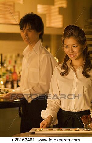 Waitress carrying a plate of food to a table View Large Photo Image Stock Image - Waitress carrying a plate of food to a table. Fotosearch