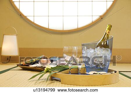 Wine bottle in ice bucket on tray with glasses and a flower in a Japanese room View Large Photo Image Stock Photo - Wine bottle in ice bucket on tray with glasses and a flower in a Japanese room. Fotosearch