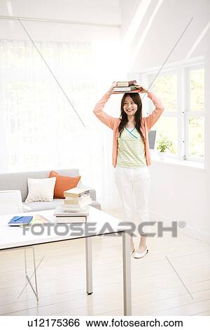 Woman balancing books on her head View Large Photo Image Stock Photograph - Woman balancing books on her head. Fotosearch