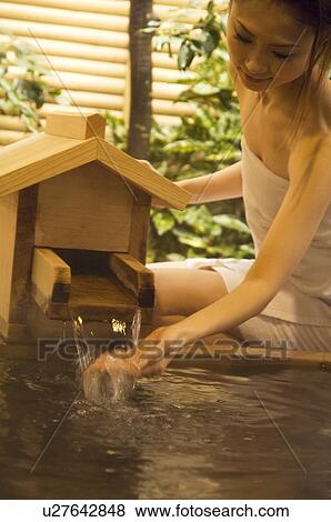 Stock Photo - Woman checking the temperature of a hot tub. Fotosearch