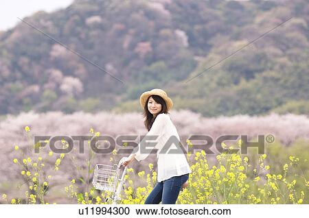 Woman cycling through spring landscape View Large Photo Image Stock Image - Woman cycling through spring landscape. Fotosearch