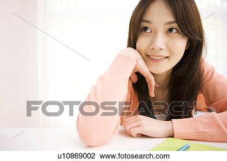 Woman daydreaming at her desk View Large Photo Image Stock Image - Woman daydreaming at her desk. Fotosearch