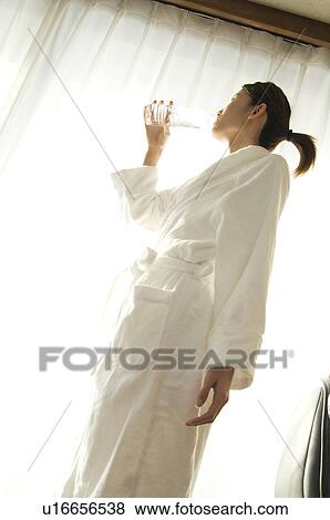 Woman drinking water from a bottle View Large Photo Image Stock Photo - Woman drinking water from a bottle. Fotosearch