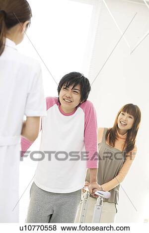 Stock Photo - Woman encouraging her boyfriend with his rehabilitation. Fotosearch