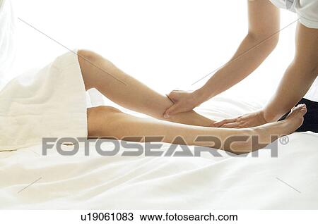 Stock Image - Woman has her legs massaged. Fotosearch