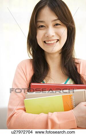 Woman holding her workbooks View Large Photo Image Picture - Woman holding her workbooks. Fotosearch