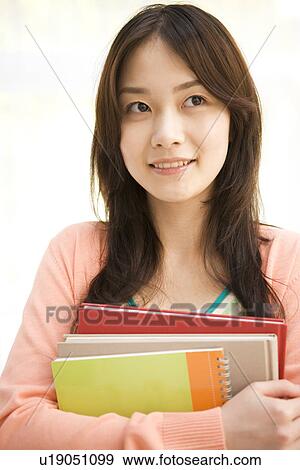 Stock Photo - Woman holding her workbooks. Fotosearch