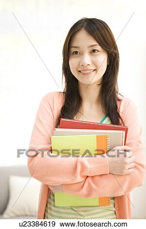 Stock Photo - Woman holding her workbooks. Fotosearch