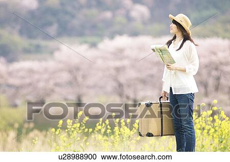 Woman holding suitcase and map View Large Photo Image Stock Image - Woman holding suitcase and map. Fotosearch